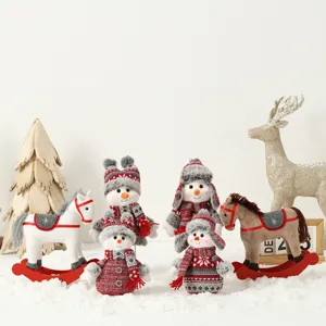 Décorations de bonhomme de neige et cheval à bascule en peluche sur fond de neige blanche