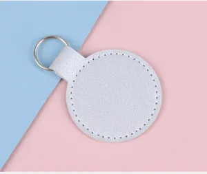 Vue détaillée d'un porte-clés circulaire en cuir argenté texturé avec anneau métal