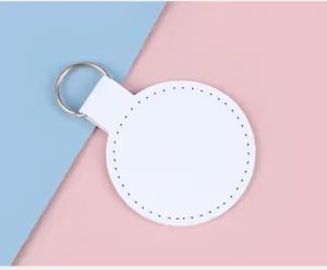 Détail macro d'un porte-clés circulaire en cuir blanc avec coutures fines