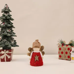 Detailed shot of a plush red Christmas angel ornament with a gold star and knit hat