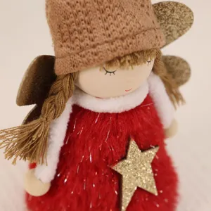 Macro detail view of red plush dress and gold star on Christmas angel hanging doll