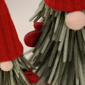 Primo piano di uno gnomo di Natale fatto a mano con cappello rosso e strisce di feltro