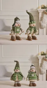Close-up of green plush Christmas snowman figurines with skis in a cozy home setting
