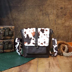Western style cow print crossbody bag with vintage brown faux leather and wide strap.