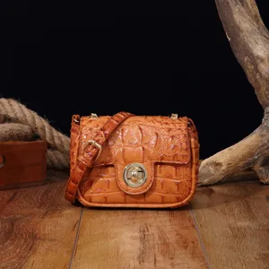 Detalle de bolso bandolera vintage naranja con relieve de cocodrilo y herrajes dorados