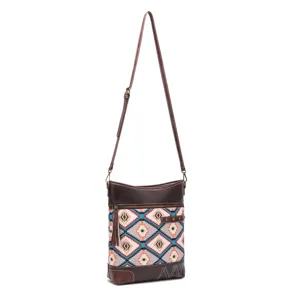 Vintage bohemian Aztec print crossbody bag with brown leather trim and tassel detail.