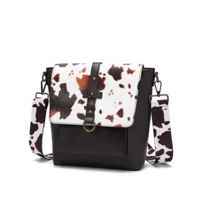 Frontal view of retro western crossbody bag with cow print flap and wide strap