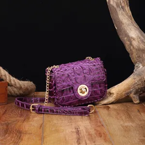 Detalle de la textura de cocodrilo púrpura en bolso bandolera retro de lujo para mujer