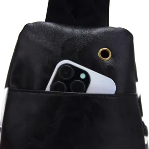 Close-up of black retro sling bag showing front pocket storage for a mobile phone.