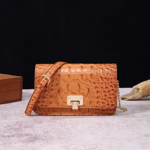 Bolso de hombro vintage marrón para mujer con textura de cocodrilo de lujo y cierre dorado.