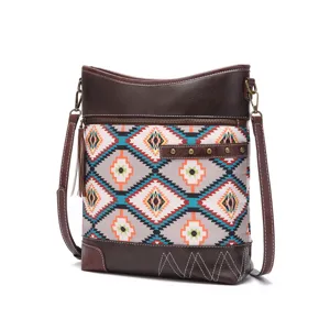 Detail shot of bohemian Aztec print crossbody bag with tassel and brass hardware