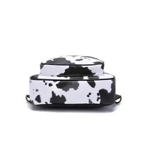 Bottom view of a small Western-style chest bag with black and white cow print pattern.