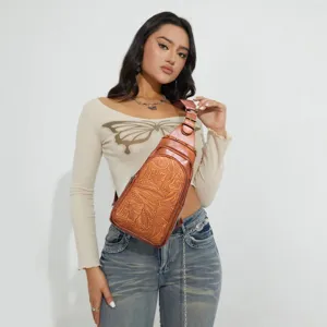 Floral embossed vintage western sling bag worn by a model in a lifestyle shot