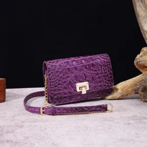 Vista detallada de un elegante bolso retro morado con textura de piel de cocodrilo