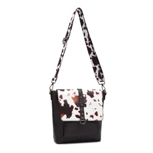 Detailed view of a vintage western crossbody bag with cow print pattern and wide strap