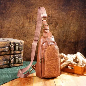 Vintage Bohemian sling bag with embossed floral patterns and a patterned strap.