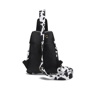 Rear view of a vintage sling bag with cow print strap and black PU leather finish