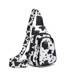 Close-up detail of the stylish black and white cow print chest bag with dual zipper pockets