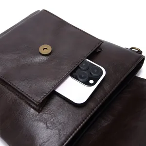 Close-up detail of vintage leather bag showing magnetic snap pocket with phone scale