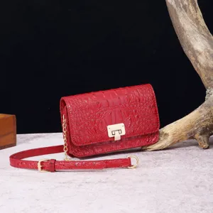 Vista detallada de un bolso retro rojo con textura de cocodrilo y cadena dorada