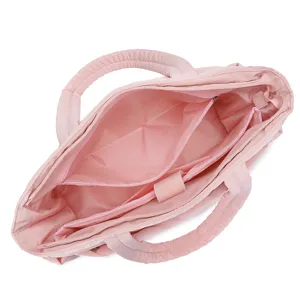 Detailed interior view of a pink quilted travel bag showing compartments and pockets
