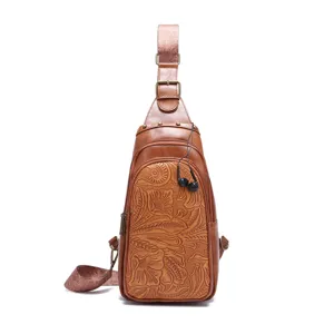 Detailed view of the intricate vintage bohemian floral embossing on a brown leather sling bag.