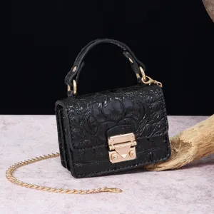 Detalle de primer plano de bolso negro de cocodrilo con un elegante cierre de metal dorado