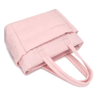Close-up view of pink quilted travel bag showing soft texture and sturdy straps