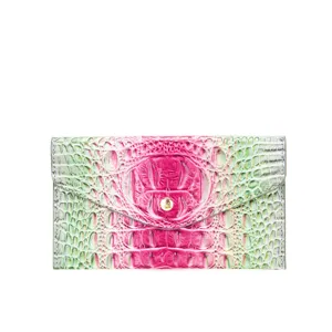 Detalle de bolso de mano con relieve de cocodrilo degradado rosa y verde con botón