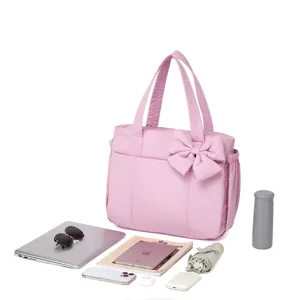 Ampia borsa shopper rosa trapuntata con laptop e oggetti essenziali per il viaggio e fitness