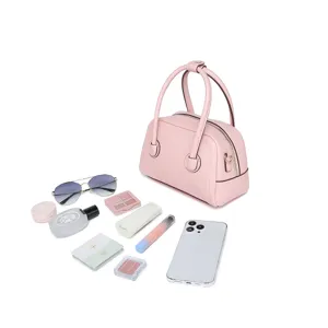 Vista de la capacidad del bolso Boston rosa de cuero con cosméticos diarios