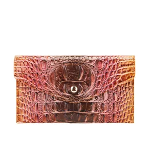 Detalle de bolso de mano vintage en piel con relieve de cocodrilo y botón dorado