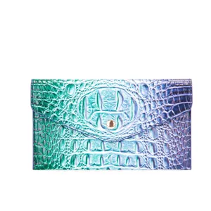 Primer plano de este bolso de mano irisado con relieve de cocodrilo y degradado azul.