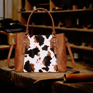 Bolso vintage con estampado de vaca en una mesa rústica de madera en un taller