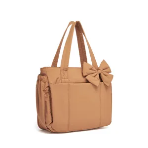 Vista dettagliata di una borsa tote in cotone imbottito color cuoio con fiocco.