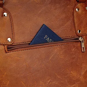 Detalle de bolso de cuero vintage marrón con bolsillo trasero con cremallera y pasaporte.