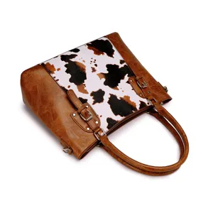 Vista detallada del bolso tote western con estampado de vaca y cuero marrón