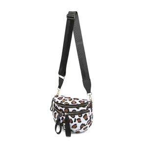 Vista detallada de un bolso bandolera de tela oxford con estampado de leopardo y cremalleras