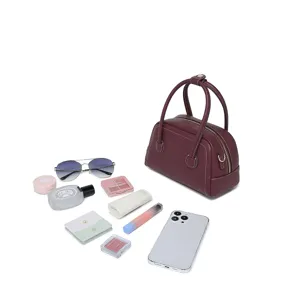 Mini bolso Boston de cuero burdeos con artículos diarios para mostrar su capacidad