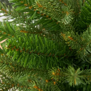 Dettaglio ravvicinato degli aghi di pino verdi realistici di un albero di Natale artificiale