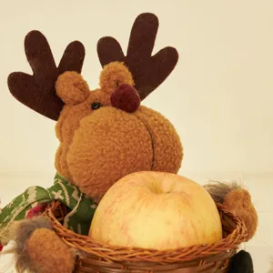 Niedliche Plüsch-Weihnachtsrentier-Figur mit einem geflochtenen Korb für Obst und Süßes