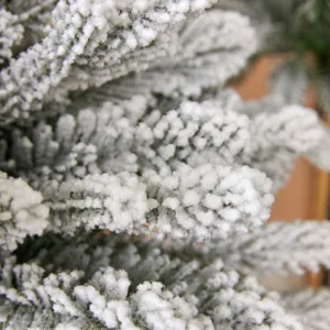 Vista macro dettagliata di un realistico albero di Natale verde innevato per decoro