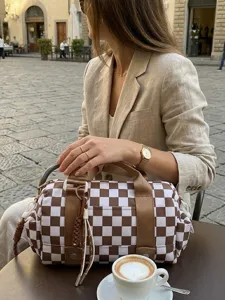 Dettaglio di una borsa da viaggio a scacchi marroni e bianchi in un caffè