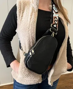 Primer plano de un bolso de pecho negro de cuero sintético con correa bohemia chic
