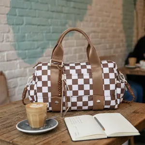 Borsa da viaggio a scacchi di grande capacità su un tavolo da caffè rustico con caffè