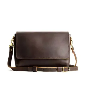 Vista detallada de un bolso bandolera vintage de cuero marrón oscuro con diseño minimalista.