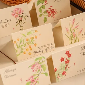Close-up of vintage kraft paper greeting cards with delicate floral watercolor illustrations.