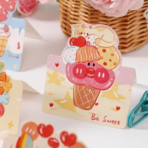 Close-up of a cute cartoon ice cream greeting card with Be Sweet text in a soft setting