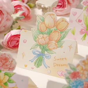 Dettaglio di un biglietto d'auguri con bouquet di tulipani e la scritta Sweet Dreams