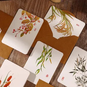 Vista detallada de tarjetas de felicitación de acuarela vintage con sobres kraft y motivos de plantas.